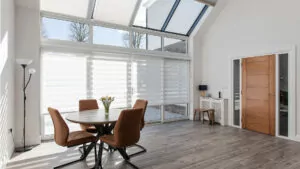 Beautiful modern dining room showing benefits of self build home with motorised aura day night blinds and cellular roof window blinds