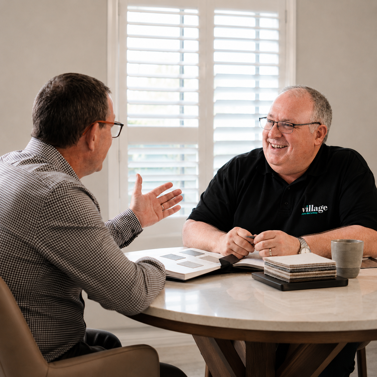 Village Blinds and Shutters design consultant discussing window samples with a customer during a home appointment