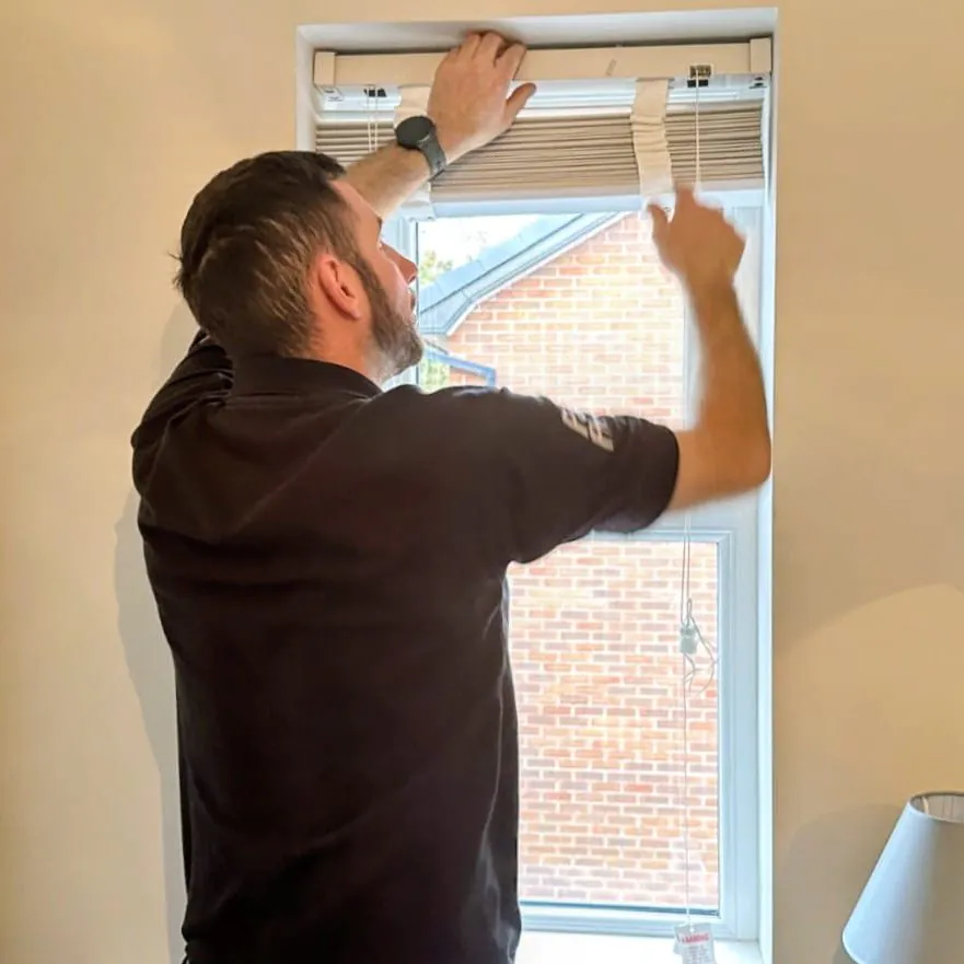 Village Blinds fitter installing a made-to-measure blind at a window