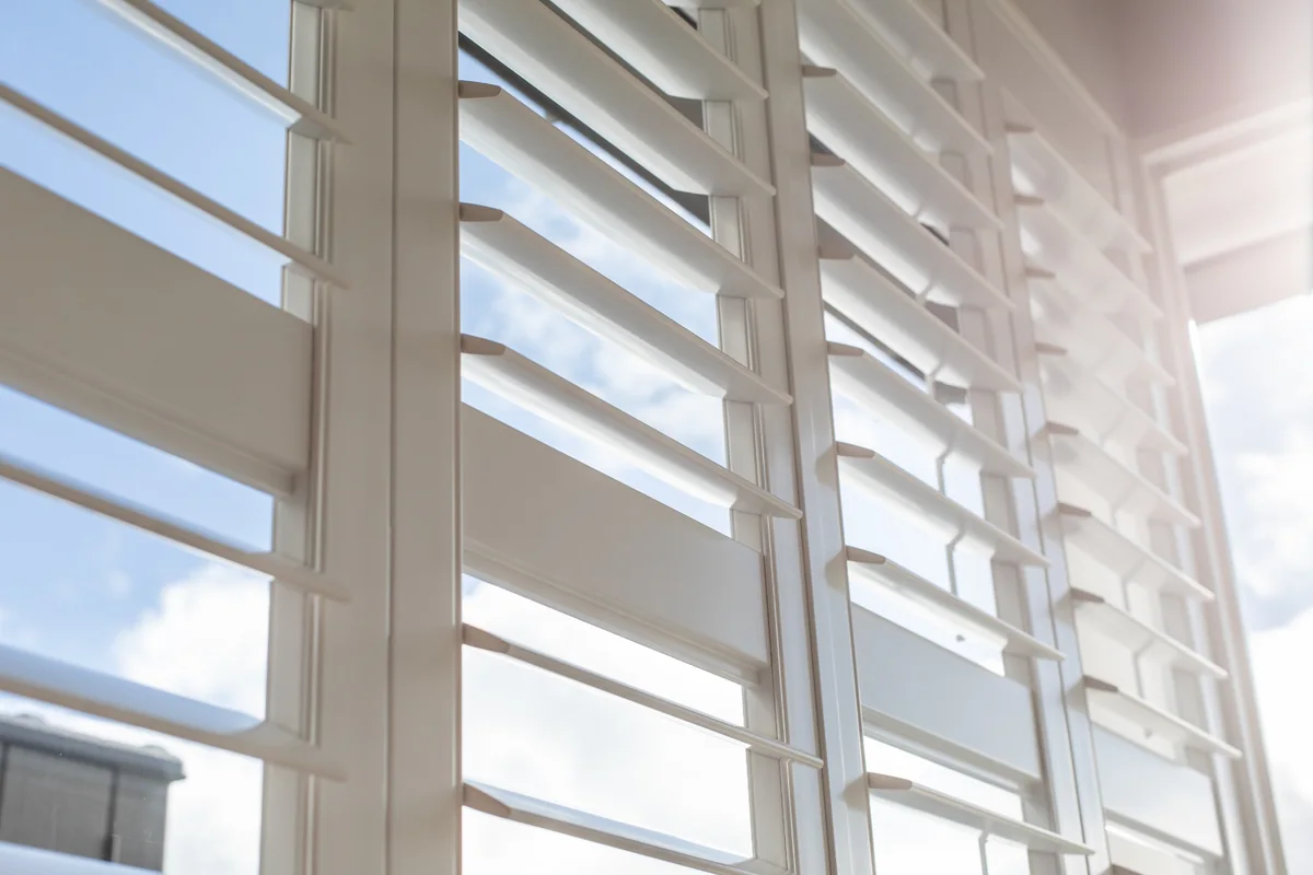 Close-up of white plantation shutter louvres and mid rail