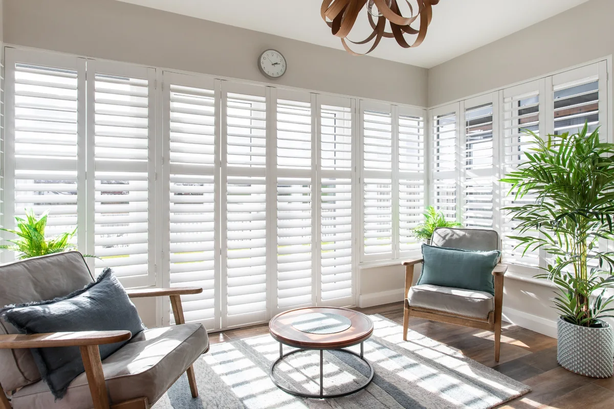 Wide full height shutter installation with balanced panel layout in a living room
