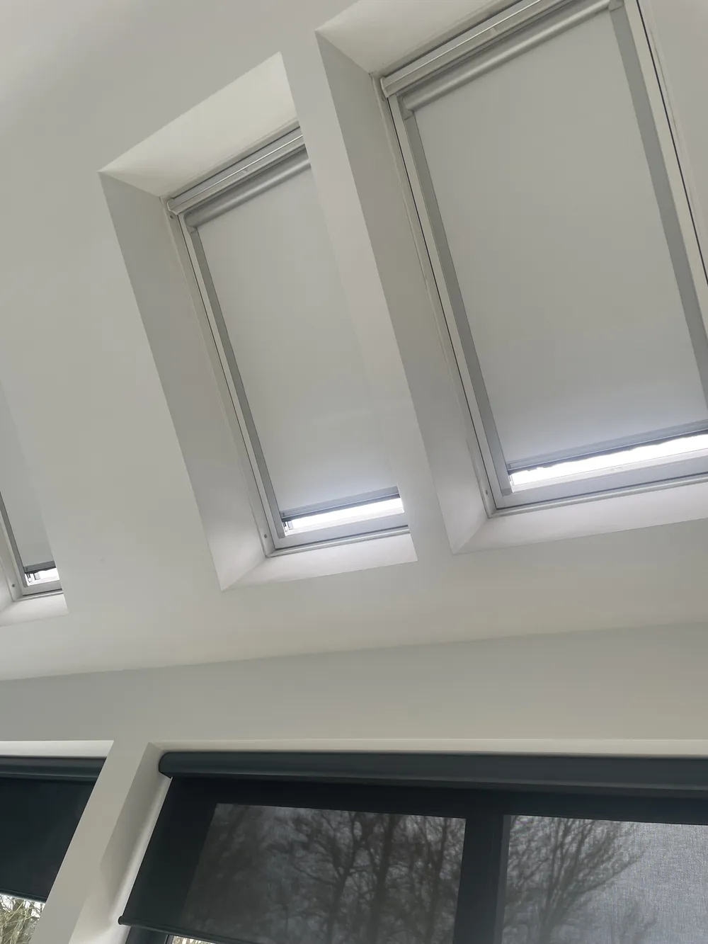 Several white roof window blinds fitted to high skylights above dark blinds in a contemporary Northern Ireland room