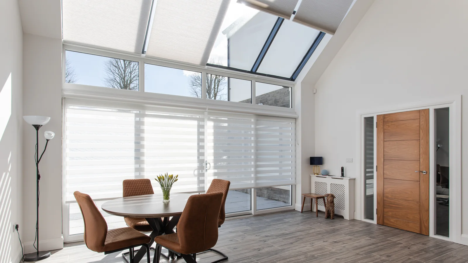 Open-plan room with white roof window blinds fitted across sloping glazing above a dining area in a Northern Ireland home