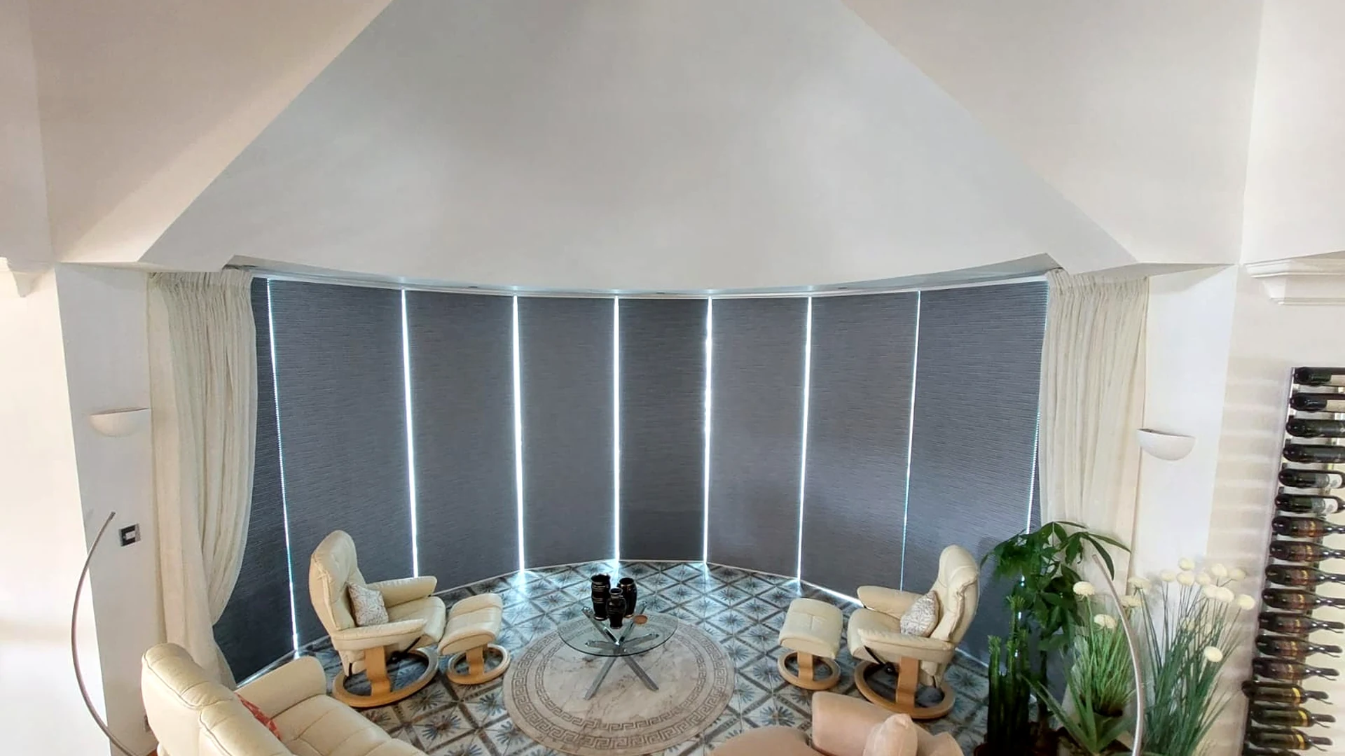 Dark cellular blinds fitted across a large curved glazed room