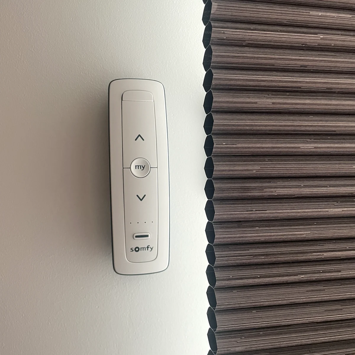 Somfy remote beside the cellular edge of a motorised honeycomb blind