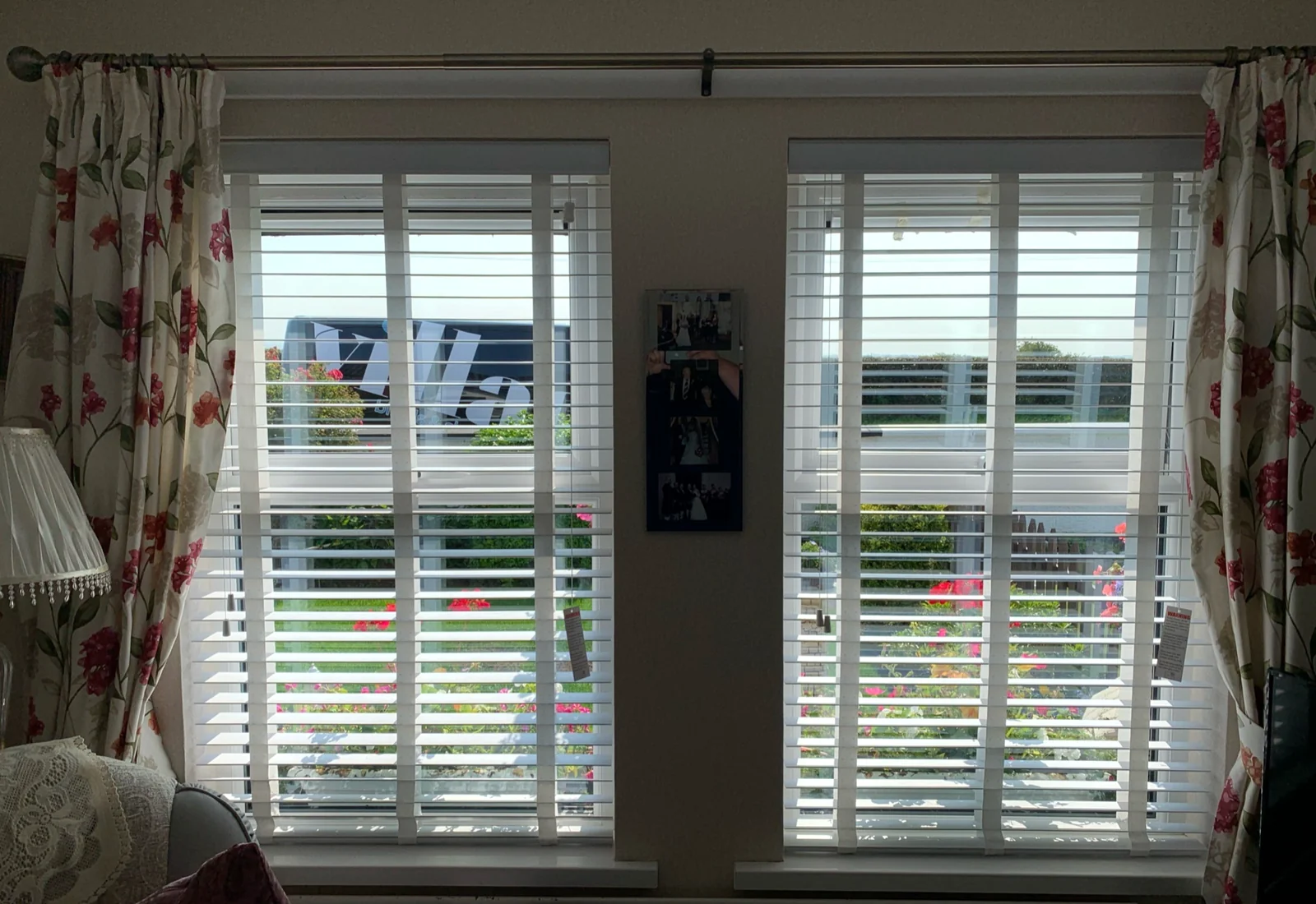 White wooden blinds controlling daylight across two living room windows