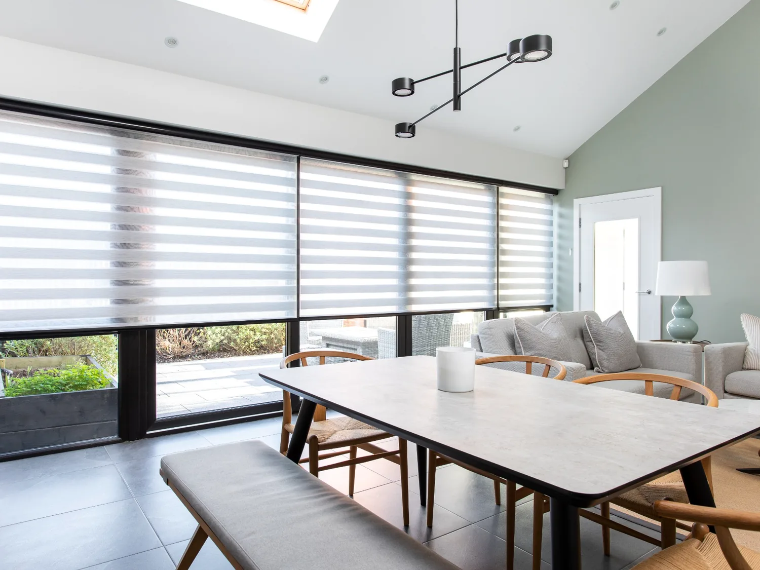Motorised Day and Night blinds across an open-plan dining and living space