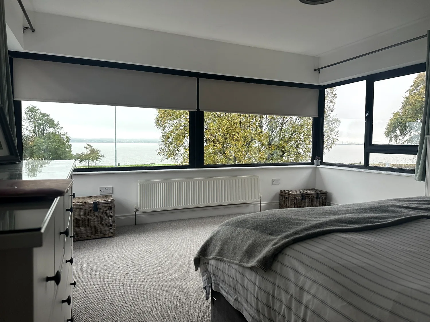 Motorised roller blinds controlling light in a modern bedroom