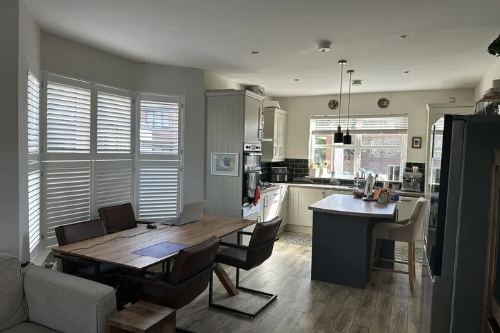 Open-plan kitchen and dining area with Tier-on-Tier shutters fitted to a bay window