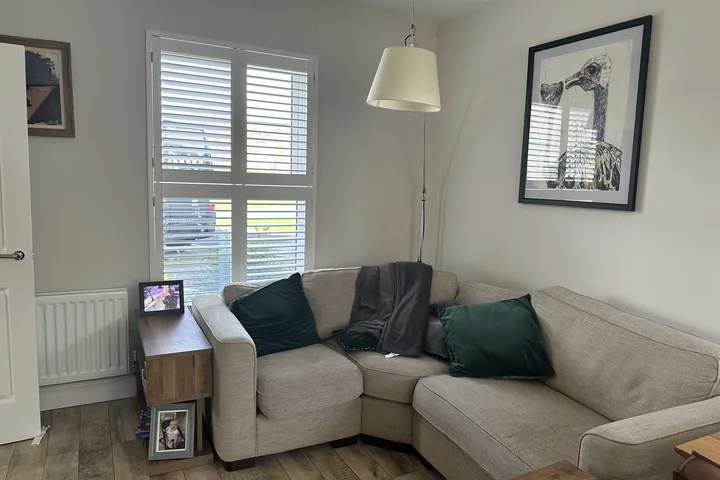 Living room with white Tier-on-Tier shutters fitted to a tall window