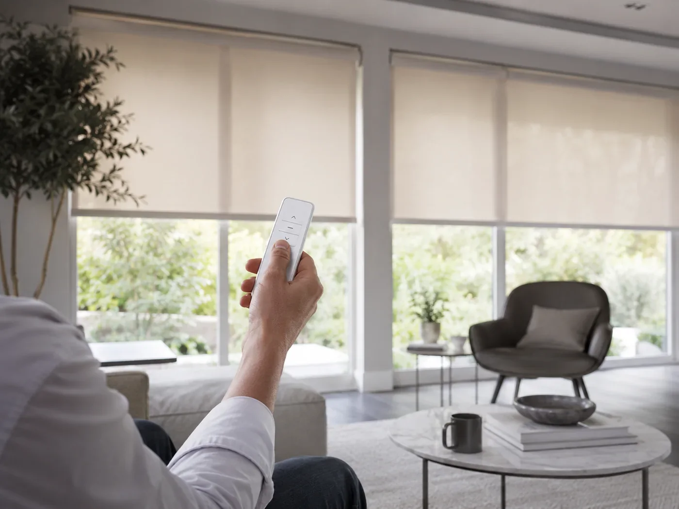 Person using a handheld remote to operate motorised roller blinds