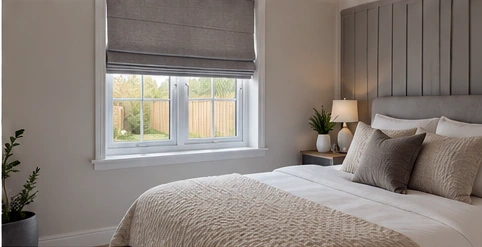 Calm double bedroom with a tailored Roman blind, illustrative of a Lisnacastle Gardens home.