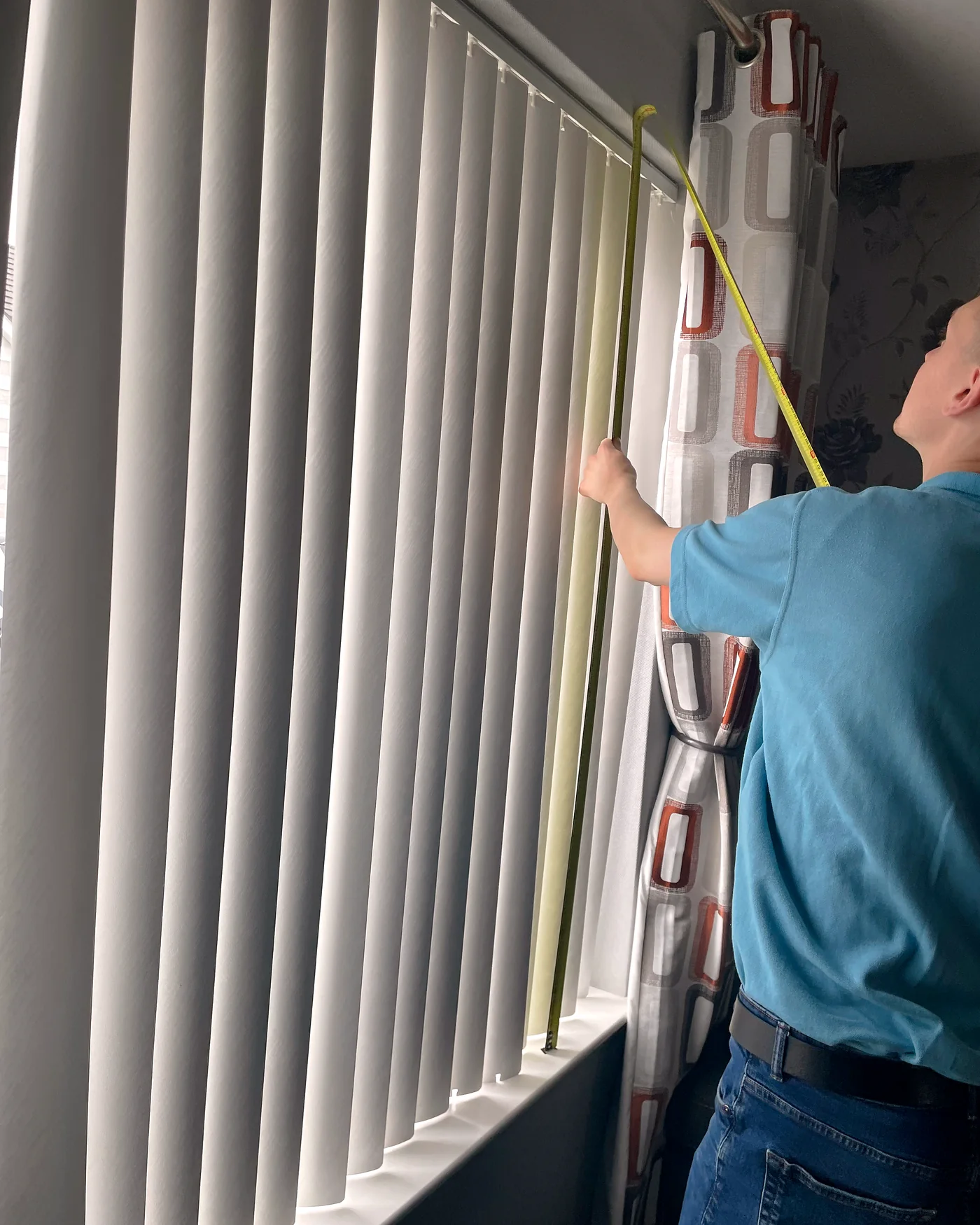 Village team member professionally measuring a window for a made-to-measure blind