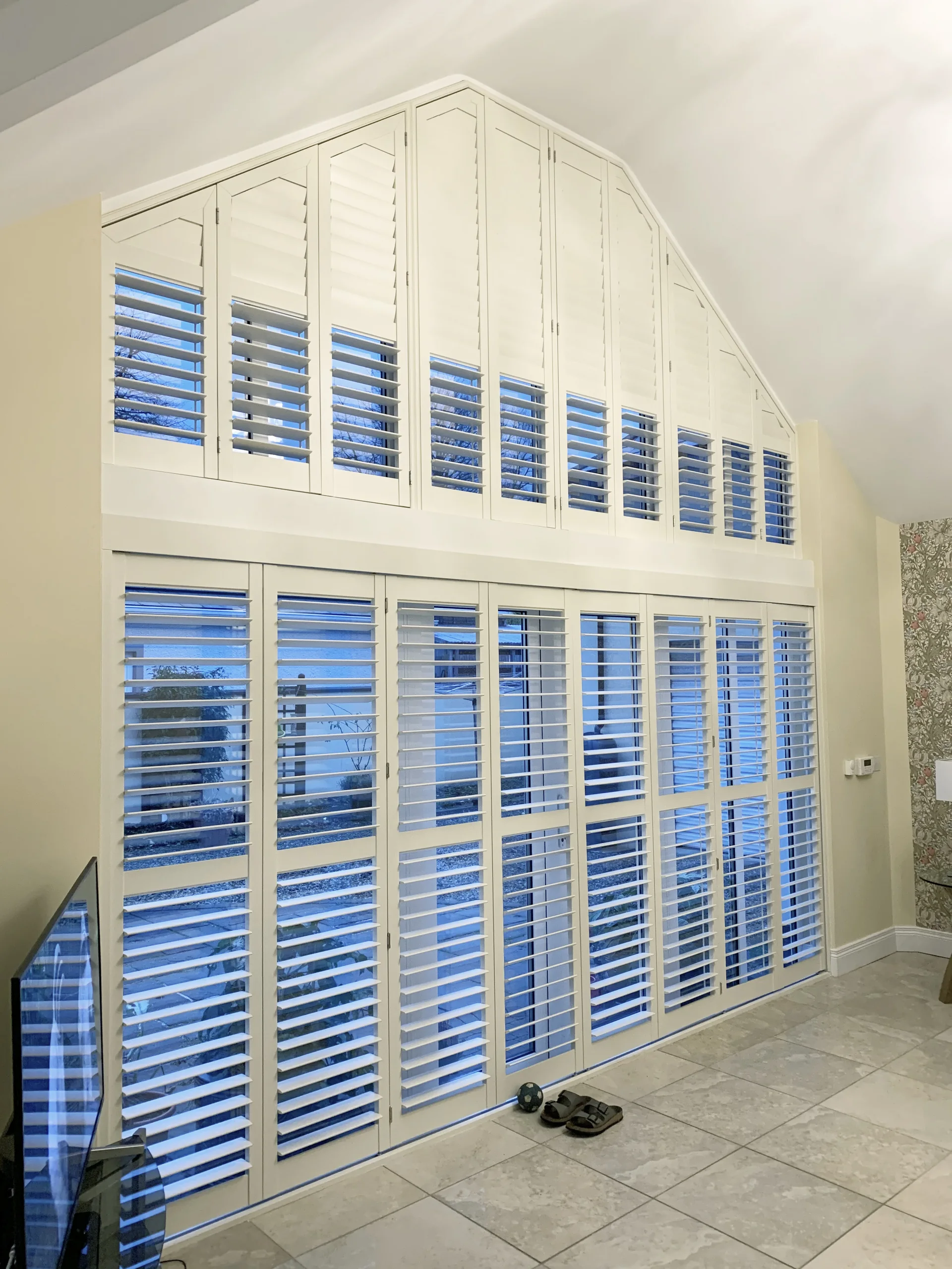 Made-to-measure plantation shutters across large shaped glazing in a Northern Ireland home