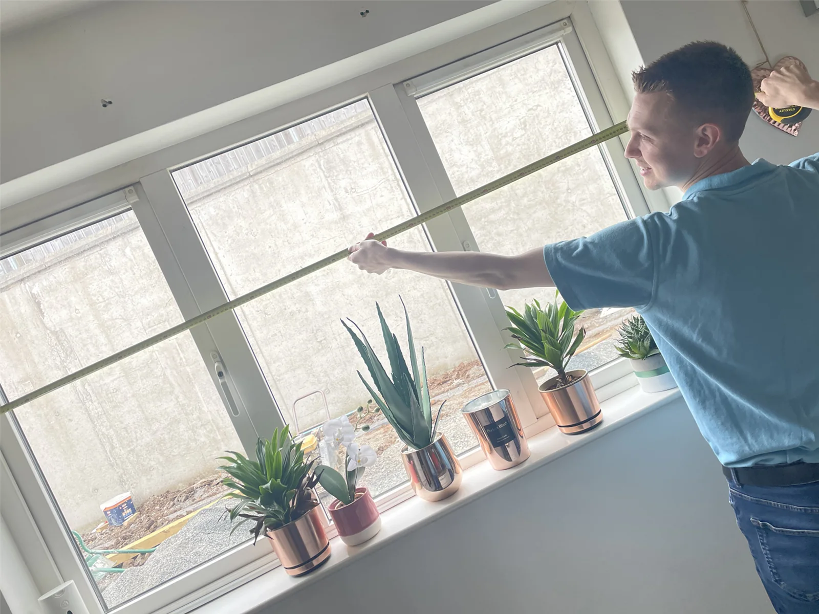 Village team member professionally measuring a window for made-to-measure blinds