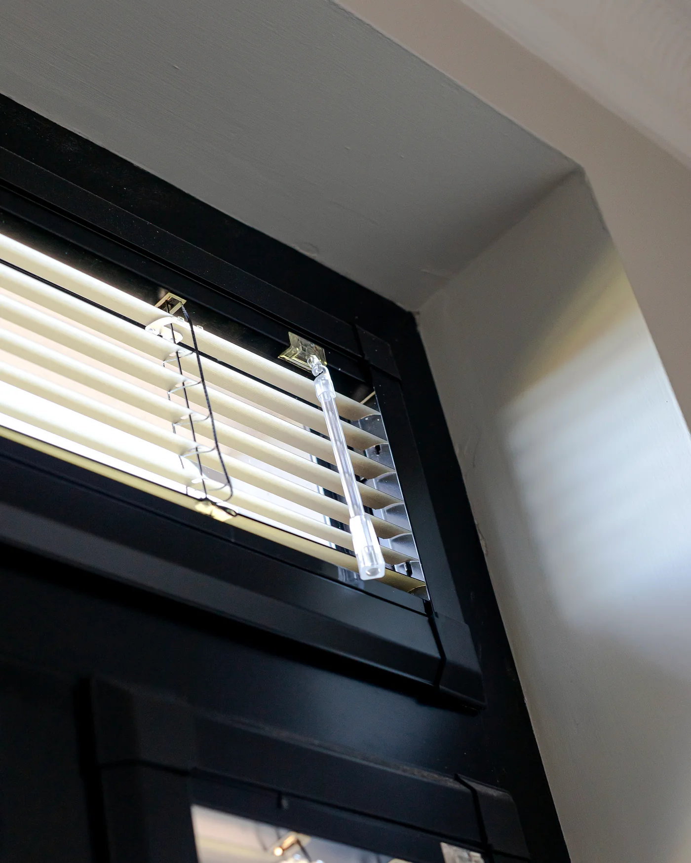 Close-up of Perfect Fit Venetian blinds fitted neatly within a dark window frame
