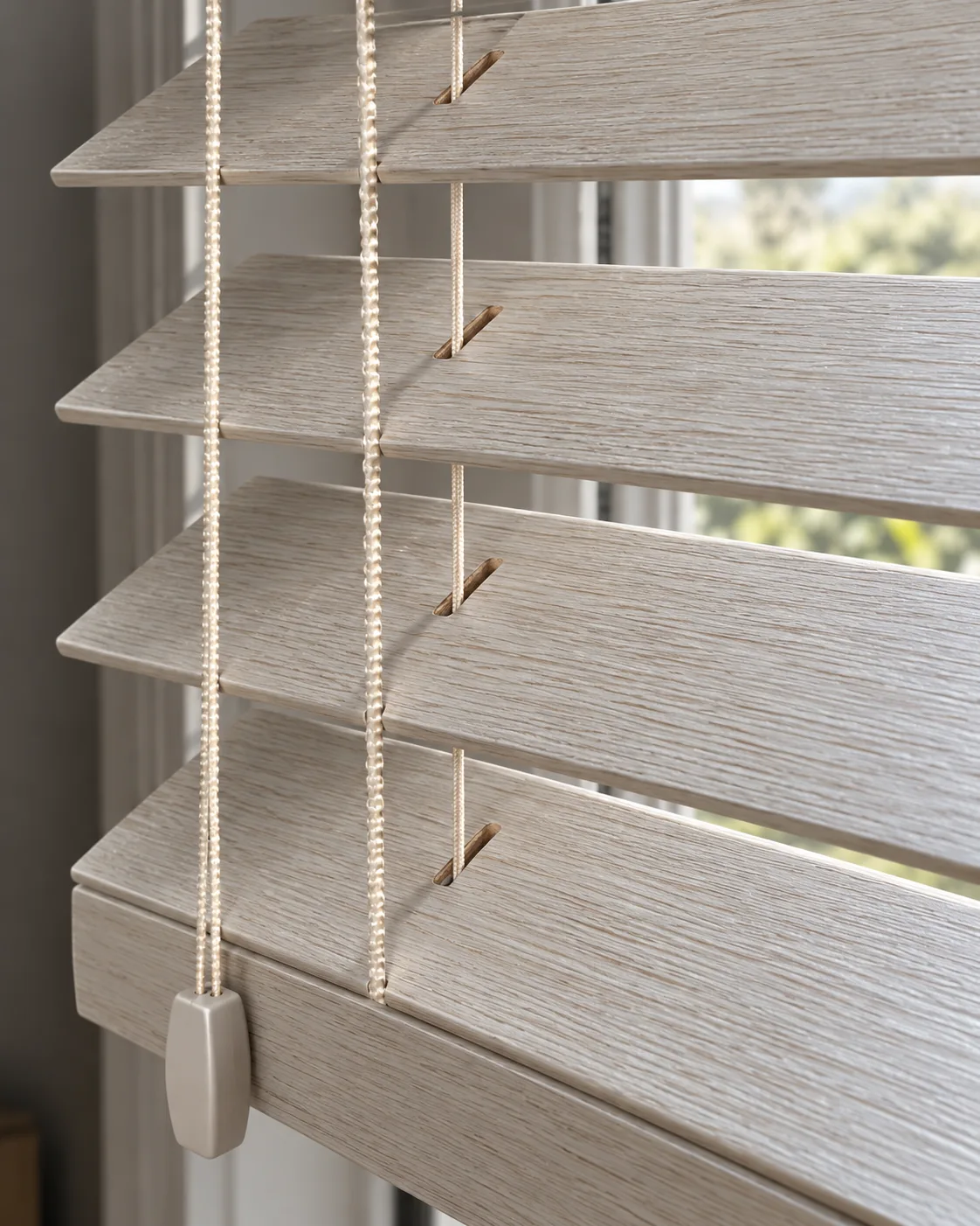 Close-up of Linen 50mm wooden Venetian blind slats showing pale woodgrain texture and corded construction without decorative tapes.